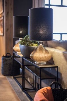 a living room filled with furniture and a lamp on top of a coffee table in front of a window