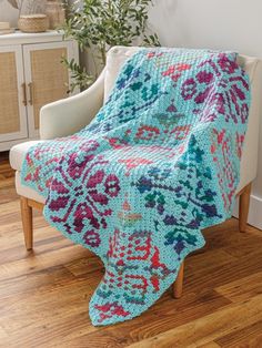 a crocheted blanket sitting on top of a chair