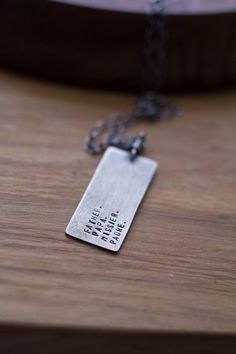 a silver necklace that says, there is no place like home