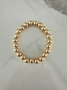 Perfect worn on its own or layered with our other bracelets. 18k gold filled 8mm beads  6", fits up to 6.5" Ready to ship *18k gold filled is a more affordable alternative to solid gold jewelry. Gold filled is a layer of gold bonded onto a base metal with heat and pressure that contains 100+ times more gold than gold plated jewelry.  *It is very durable and tarnish resistant.  *With proper care, gold filled jewelry can last several years. Avoid contact with harsh chemicals, perfumes, water, etc.  *Gold filled jewelry can be worn by people with sensitive skin because it is hypoallergenic, lead free and nickel free. Everyday Gold Beaded Stretch Bracelet, Elegant Stretch Bracelet With 14k Gold-filled Gold Beads, Gold 14k Gold-filled Beaded Bracelets, Elegant 14k Gold-filled Stretch Bracelet With Gold Beads, Gold Hand-strung Stretch Bracelet In 14k Gold-filled, Gold Stretch Bracelet With 14k Gold-filled Beads, Elegant Hypoallergenic Gold Stretch Bracelet, Gold 14k Gold-filled Round Beads Bracelets, Gold Bracelet With Spacer Beads In 14k Gold Filled