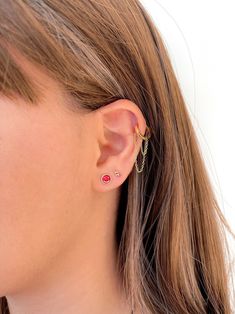 a close up of a person wearing a pair of ear piercings on their ears