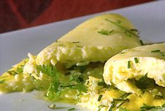 an omelet is on a white plate with green garnish