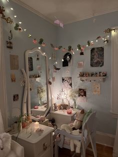 a bedroom with a vanity, mirror and lights on the wall above it's desk