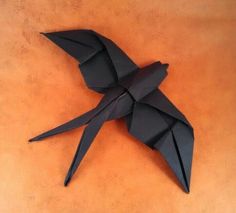 a black origami bird sitting on top of a table