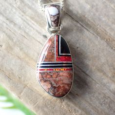 This stunning sterling silver set is created and stamped by Navajo artist Sheryl Martinez. It features an inlay design of Wild Horse, Jet & Opal. The earrings measure 1.2" long including the ear wire by 0.4" wide. The pendant measures 1.3" long (from the top of the bail) by 0.5" wide.Pictured on a 1 mm chain which is sold separately here. Artisan Red Jewelry With Inlay, Artisan Red Inlay Jewelry, Red Sterling Silver Jewelry With Inlay, Artisan Red Sterling Silver Jewelry, Southwestern Jewelry With Inlay For Gifts, Southwestern Style Jewelry With Inlay For Gift, Southwestern Style Inlay Jewelry As Gift, Southwestern Silver Jewelry With Inlay, Southwestern Oval Jewelry With Polished Finish