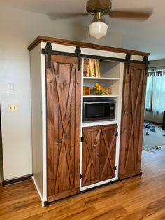 the entertainment center is made out of wood and has sliding doors on both sides to open it up