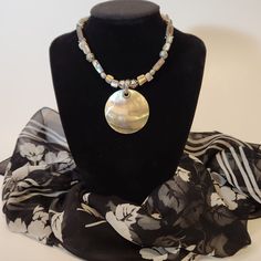 Introducing our stunning Abalone Pendant Necklace, a true embodiment of ocean elegance. This wonderful pendant glows like a beautiful sunset. This exquisite piece features a 2" diameter circle of luminescent abalone, accented with abalone beads and silver-toned bead and chain details. The adjustable length ranges from 18" to 20", ensuring a perfect fit for any occasion. Elevate your style with this unique, handcrafted necklace that captures the iridescence of the sea. In great pre-loved vintage Handmade Iridescent Necklace With Round Pendant, Iridescent Necklace With Large Pendant In Unique Style, Gold Bohemian Abalone Shell Necklace, Iridescent Nickel-free Spiritual Necklaces, Bohemian Iridescent Round Bead Jewelry, Iridescent Bohemian Necklace As Gift, Elegant Adjustable Abalone Shell Necklace, Bohemian Iridescent Necklace As A Gift, Adjustable Iridescent Round Necklaces