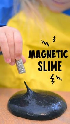 a child is playing with a magnet slime on a black rock that says, magnetic slime