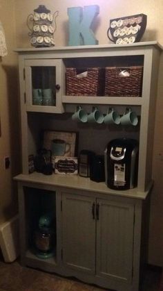 a gray hutch with cups and mugs on it