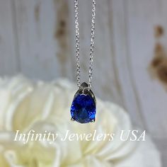 "The pendant pictured is a lab created blue sapphire #6864 -Approximate total carat weight: approx. 2.00ctw diamond equivalent -Center Stone Size: 10x7mm - approx. 2.00ct diamond equivalent -Center Stone Shape: pear -Gem Type: lab created sapphire -Stone Clarity: VS2 -Stone Color: Blue -Moh's Scale: 9 hardness -Metal Type and Purity: 14k yellow gold -Setting: 3 prong basket design -Chain: delicate 14k gold chain / heavier option with lobster claw available (use dropdown to select) -Country of Ma Blue Sapphire Drop Jewelry, Blue Drop Gemstone Jewelry, Blue Gemstone Drop Jewelry, Fine Jewelry Blue Necklace For Anniversary, Blue Fine Jewelry Necklace For Anniversary, Blue Necklaces For Anniversary In Fine Jewelry Style, Classic Blue Necklaces With Accent Stones, Blue Sapphire Drop Necklaces, Classic Blue Necklace With Accent Stones