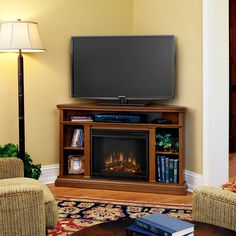 a flat screen tv mounted on top of a wooden entertainment center next to a fire place