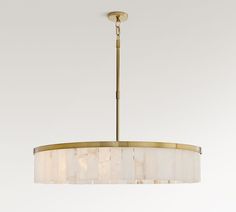 a chandelier hanging from the ceiling with white and beige shades on it's lampshade