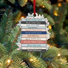 a book ornament hanging from a christmas tree with books stacked on it's back