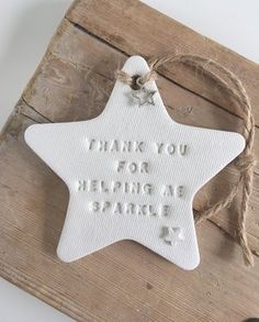 a white ceramic star ornament with words on it that says, thank you for helping me share