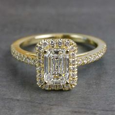 an emerald cut diamond ring with two rows of diamonds around the band