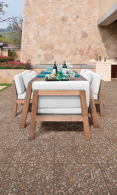 an outdoor dining table and chairs with bottles of wine on it