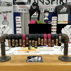 the display features several different types of belts on metal stands, including one for women's shirts and one for men's t - shirts