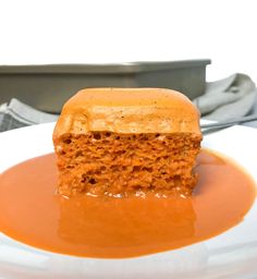 a piece of carrot cake with caramel sauce on a white plate