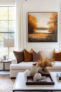 a living room filled with furniture and a painting on the wall above it's coffee table