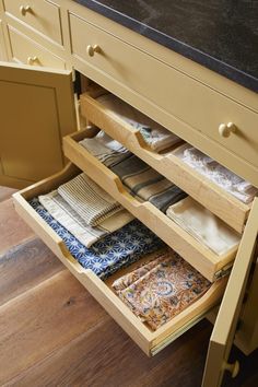 an open drawer in a kitchen filled with folded and unwrapped napkins