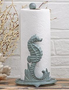 a white toilet paper holder with a seahorse on it