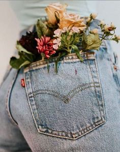 a person wearing jeans with flowers in the back pocket on their stomach, and there is no image to describe