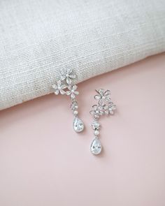 Delicate pear shape dangle earring seamlessly blend with floral rhinestones and accented with small pearls adds a classic touch for your ensemble. Pair them with an elegant dress for formal affair, or let them elevate your casual style. Perfect for date night, wedding, bridesmaids, holiday party, and any special occasions. DETAILS: LENGTH: 1.75"COLOR: SILVERIMPORTED MATERIALS Elegant Crystal Bridal Earrings For Pierced Ears, Elegant Bridal Crystal Earrings For Pierced Ears, Elegant Crystal Bridal Earrings, Elegant Pear-shaped Chandelier Earrings For Formal Occasions, Crystal Embellished Drop Earrings For Wedding, Elegant Silver Crystal Flower Earrings, Elegant Pear-shaped Chandelier Earrings As Gift, Formal Dangle Flower Earrings With Cubic Zirconia, Crystal Embellished Bridal Drop Earrings For Wedding