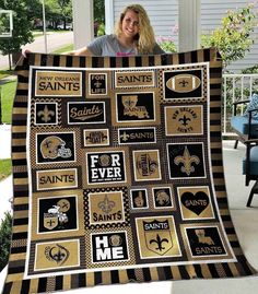 a woman is holding up a blanket that has saints and other sports related items on it