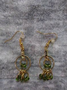 Green Dangle Hoop Earrings With Beaded Fringey Bottoms MATERIALS: -GREEN GLASS SEED BEADS -RUBBER EARRING BACKINGS -GOLD PLATED ALLOY METAL JUMP RINGS, EARRING WIRES AND HOOP EARRING FINDINGS Introducing our chic and trendy Green Dangle Hoop Earrings. These eye-catching earrings are designed to add a touch of elegance to any outfit. Made with high-quality materials, the hoops feature a stunning green color that is sure to complement any skin tone. The beaded fringey bottoms add a playful and sty Earring Wires, Dangle Hoop Earrings, Glass Seed Beads, Earring Findings, Jump Rings, Green Glass, Green Color, Statement Earrings, Skin Tones