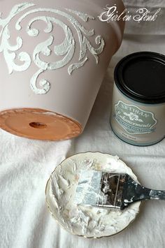 a paint can sitting on top of a table next to a plate with a brush