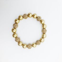 Add a touch of glamour to your outfit with this stunning bracelet. Made with gold faux pearls and gold plated zircon balls, this bracelet is the perfect accessory for any occasion. ⚜Item Specifics❀ Gold Faux Pearls❀ Gold Plated Zircon Balls❀ 15.5cm Elegant Pearl Stretch Bracelet For Party, Elegant Stretch Bracelet For Party, Gold Beaded Pearl Bangle Bracelet, Gold Beaded Bangle Pearl Bracelet, Elegant Beaded Bling Bracelets For Party, Festive Gold Pearl Bracelets, Elegant Gold Stretch Bracelet For Formal Occasions, Festive Gold Pearl Bracelet, Gold Beaded Bangle Crystal Bracelet