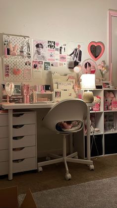 a white desk topped with lots of drawers next to a wall covered in pictures and photos