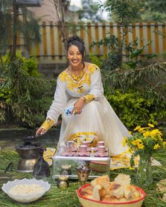 a woman sitting on the ground in front of some food