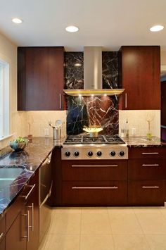 a kitchen with marble counter tops and dark wood cabinets, along with stainless steel appliances