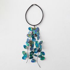 a necklace with blue and green beads hanging from it's side