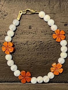 Evoking the beauty and warmth of Hawaii, this approximately 7-inch bracelet is made with white iridescent round glass beads accented with light wooden plumeria beads. With a lobster claw clasp, this bracelet will brighten your wrist and your day no matter what the weather outside may bring. Plumeria | White iridescent | Hawaiian-inspired | Beach-inspired | Unique jewelry | Tropical-inspired | Elegant bracelet | Stylish bracelet | Beaded bracelet | Unique bracelet | Gift for her | Hawaiian jewelry | Hawaiian bracelet Handmade White Crystal Bracelet With Flower Shape, Handmade White Crystal Bracelet In Flower Shape, Handmade White Crystal Flower Bracelet, Adjustable White Bracelets For Jewelry Making, Adjustable White Crystal Bracelet Gift, White Hand-strung Pearl Bracelet With Round Beads, Hand-strung White Pearl Bracelet With Round Beads, Hand-strung White Pearl Bracelet, Handmade White Pearl Bracelet Gift