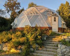 a house with a glass dome on the roof and stairs leading up to it's entrance