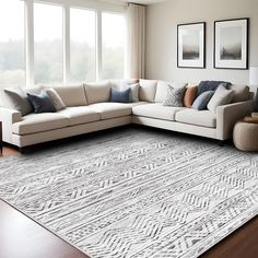 a living room with a sectional couch and large rug in front of two windows on the wall