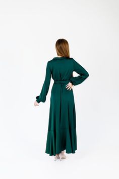 a woman in a green dress is standing back to back with her hands on her hips