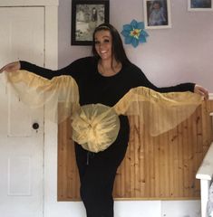 a woman standing on top of a wooden bench holding a yellow net over her belly