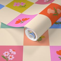 a colorful wallpaper with flowers on it and a roll of paper next to it