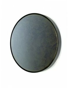 a round mirror is shown against a white wall