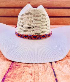 Hand beaded hat band. Orange, blue, and purple pattern. White Beaded Hat Bands For Rodeo, White Beaded Hat Band For Rodeo, Beaded Curved Brim Hat, Southwestern Beaded Brimmed Hat, White Beaded Hat Bands For Festival, Wide Brim Beaded Hat For Country Events, Festival Beaded Hat With Curved Brim, Bohemian Beach Hats With Bead Caps, Beaded Short Brim Hats For Country Events