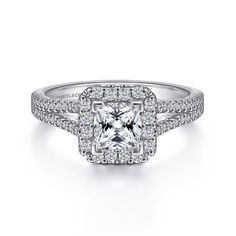 an engagement ring with a princess cut diamond surrounded by pave diamonds