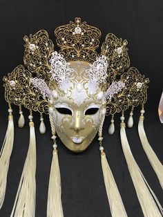 Venetian Mask for decoration - Traditional and original papier-mache Venetian mask, handmade and decorated with metal insert, gold-leaf and glitters, enriched with Swarovski crystals. Dimension::Hight 35cm,width 28cm Decoration only,not wereable All our masks are handmade paper-machè masks made in Venice. Our decorators use techniques typical of the Venetian tradition such as stucco, acrylics, gold and silver-leaf, macramè, passementerie, glitters and crequelè to offer you a wide range of origin Traditional Gold Mask For Mardi Gras, Artistic Gold Masks And Prosthetics For Festivals, Gold Carnival Masks And Prosthetics As Gifts, Gold Masks And Prosthetics For Carnival Gift, White Venetian Masks For Festivals, Traditional Gold Masks For Carnival, White Venetian Masks And Prosthetics For Festivals, Traditional Gold Masks And Prosthetics For Carnival, Gold Fantasy Headpiece For Carnival