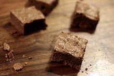 four pieces of brownie sitting on top of a wooden table