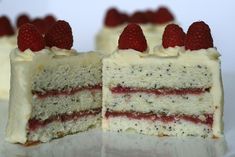 a piece of cake with white frosting and raspberries on top