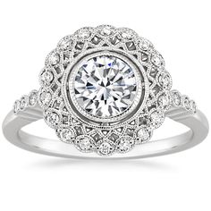 a white gold engagement ring with an oval center surrounded by round diamonds