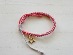 Silver and coral color string braided into a unique colorful bracelet with a cute star charm near the closure. Nylon string Metal charm Adjustable, OSFM Circumference: 5.75in Extends to: 10.25in Handmade Star-shaped Friendship Bracelets, Pink Braided Friendship Bracelets Gift, Pink Braided Friendship Bracelet Gift, Braided String Bracelet, Nylon Bracelet, Star Charm Bracelet, Mini Gift Bags, Colorful Bracelet, Color Bracelet