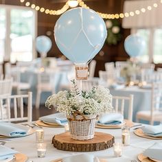 a table set up with plates, silverware and blue balloons for a wedding reception